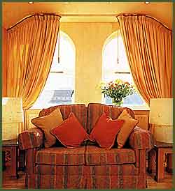 click to enlarge -  emphasing the main feature of the room the settee is upholstered with a patterned fabric which incorporates the solid colours elsewhere